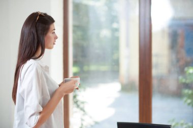 Penceresine bakarak ve Kupası tutan güzel modeli.