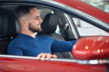 Mavi kazaklı salonda otomatik seçme çekici müşteri.