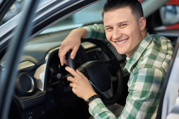 Feliz propietario del vehículo sosteniendo sus manos en el volante . — Foto de Stock