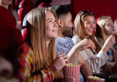 Gülümseyen güzel kadın film seyrederken.