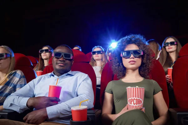 Portrait of international couple having date in cinema.