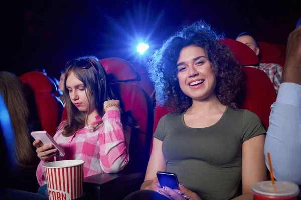 Brunette smiling and posing during film in cinema. — Stock Photo, Image