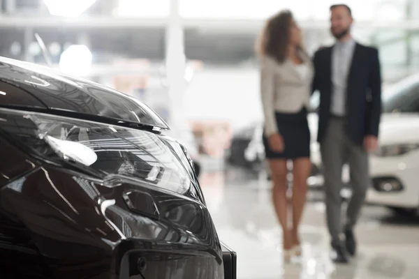 Couple choisissant auto en salle d'exposition de voiture . — Photo