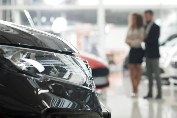 Mari et femme observant l'automobile dans la salle d'exposition de voiture . — Photo