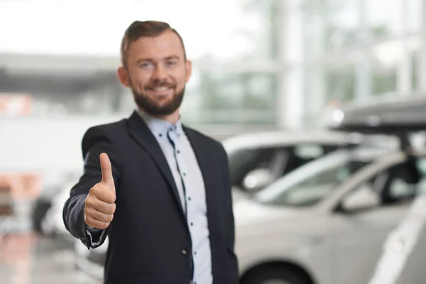Cliente feliz posando en concesionario de coches . — Foto de Stock