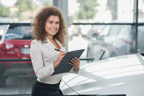 Gerente bonito de concessionária de carro posando com pasta . — Fotografia de Stock