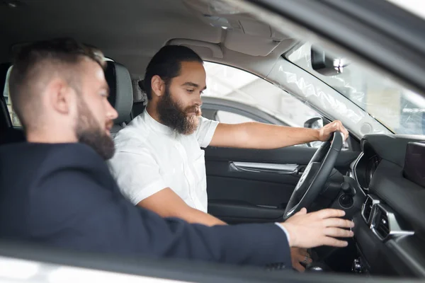 Seorang pria duduk di kabin mobil dengan dealer mobil . — Stok Foto