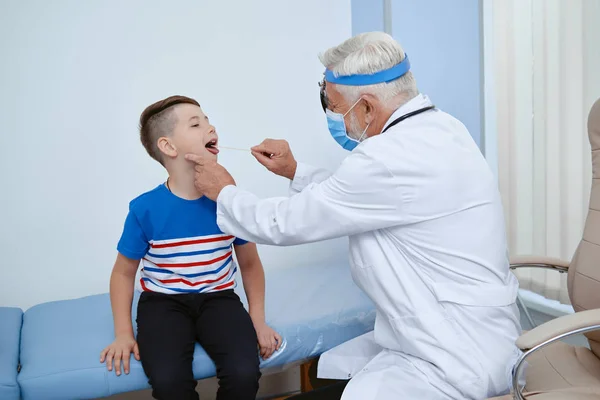 Médico en uniforme en máscara tratando a paciente joven . —  Fotos de Stock