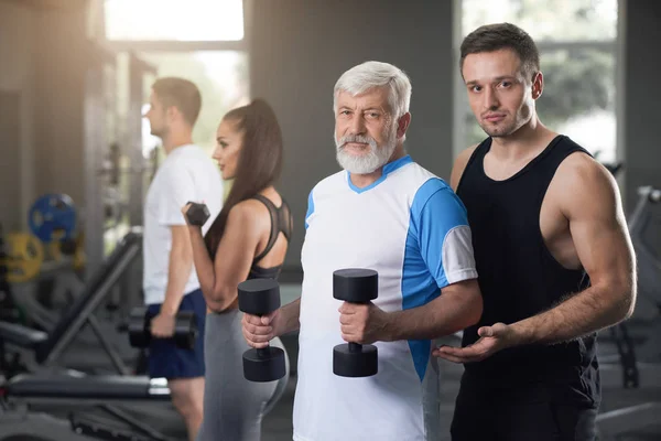 Två män tittar på kameran när du tränar i gymmet. — Stockfoto