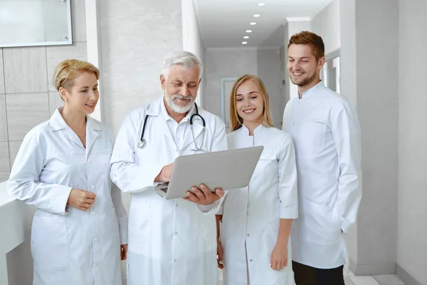 四人站在医院里的白色单片机的肖像 工作的男女成员讨论寻找治疗的解决方案 保健概念 — 图库照片