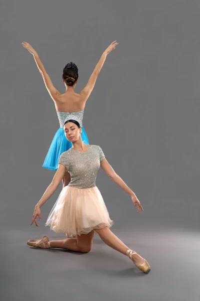 Vista frontal da bailarina sentada no joelho e apontando os dedos dos pés — Fotografia de Stock