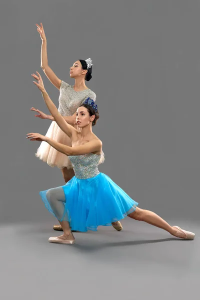 Вид сбоку на балерин, поднимающих руки и смотрящих сверху — стоковое фото