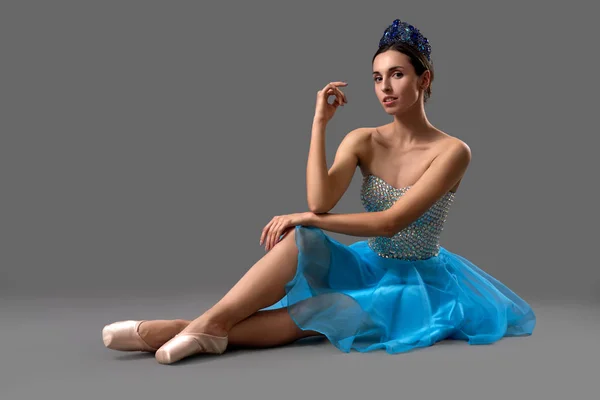 Slim μπαλαρίνα σε μπλε φόρεμα κάθεται στο πάτωμα στο studio — Φωτογραφία Αρχείου