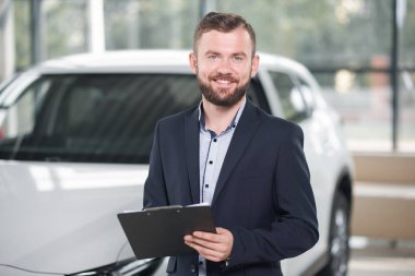 Araç Lastik Yöneticisi holding klasöründe gülümseyen.