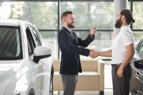 Distribuidor de coches dando llaves al cliente, estrechando las manos . —  Fotos de Stock