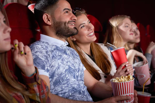 Morena árabe homem e loira sorrindo mulher no cinema . — Fotografia de Stock