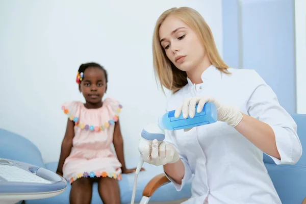 Médico y chica en vestido rosa en la oficina de médicos . — Foto de Stock