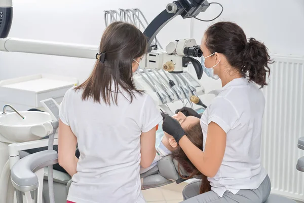 Vista desde la parte posterior de los dentistas y comprobación de los dientes del paciente — Foto de Stock