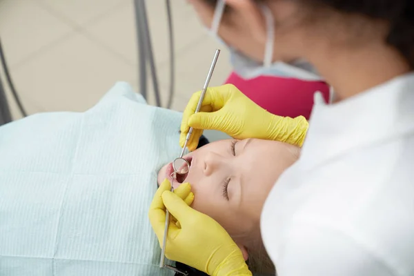 Chica acostada en la silla dental con la boca abierta en la clínica — Foto de Stock