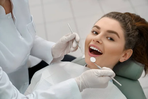 Mujer con la boca abierta mirando la cámara en el consultorio dental — Foto de Stock