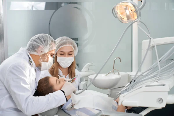 Dentistas que trabalham com o paciente na clínica . — Fotografia de Stock