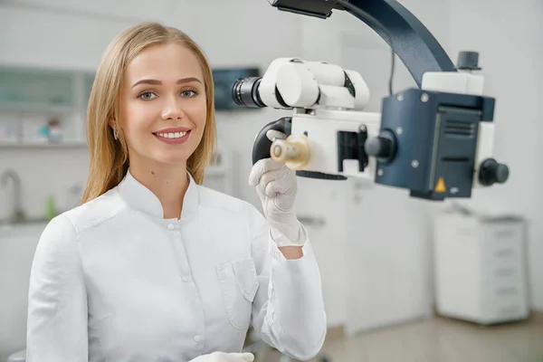 Vista frontal de la hermosa dentista femenina mirando a la cámara — Foto de Stock