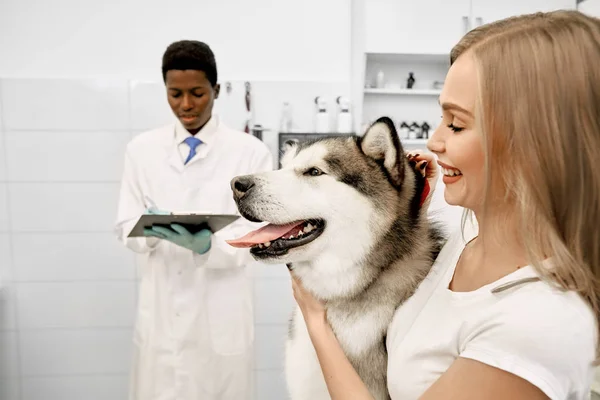 Belle donne con il suo cane in clinica veterinaria . — Foto Stock