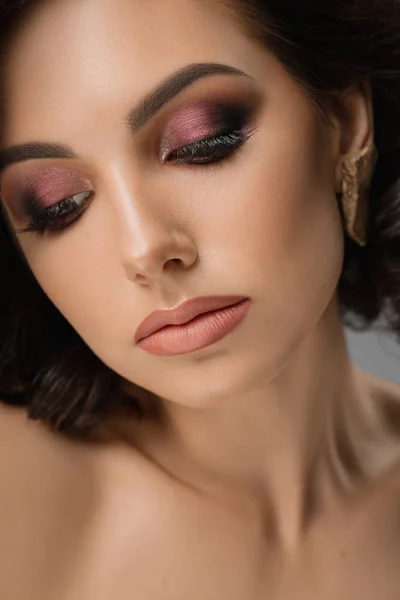 Model mit perfektem Make-up posiert vor der Kamera und blickt nach unten. — Stockfoto