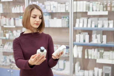 Eczane iki Kozmetik Şişeler tutan kadın.