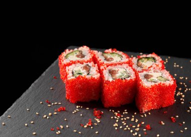 Philly kırmızı tobiko karaca, susam ile dekore edilmiş siyah taş tabakta servis ile kapalı alır. Philadelphia uramaki salatalık, somon ve krem peynir ile.