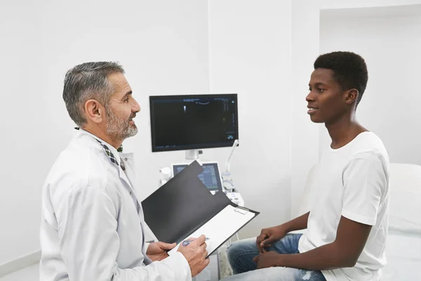 Consultazione del paziente africano con il medico nel gabinetto . — Foto Stock