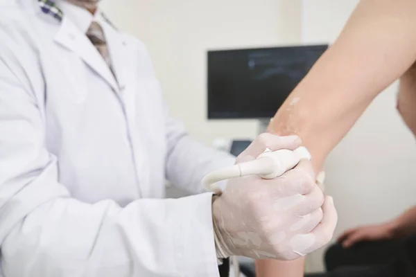 Läkare gör ultraljud diagnostik av armbåge. — Stockfoto