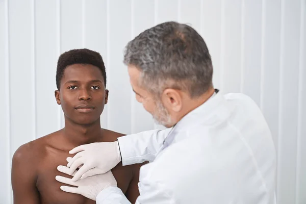 Patient africain avec torse nu à l'examen avec un médecin — Photo