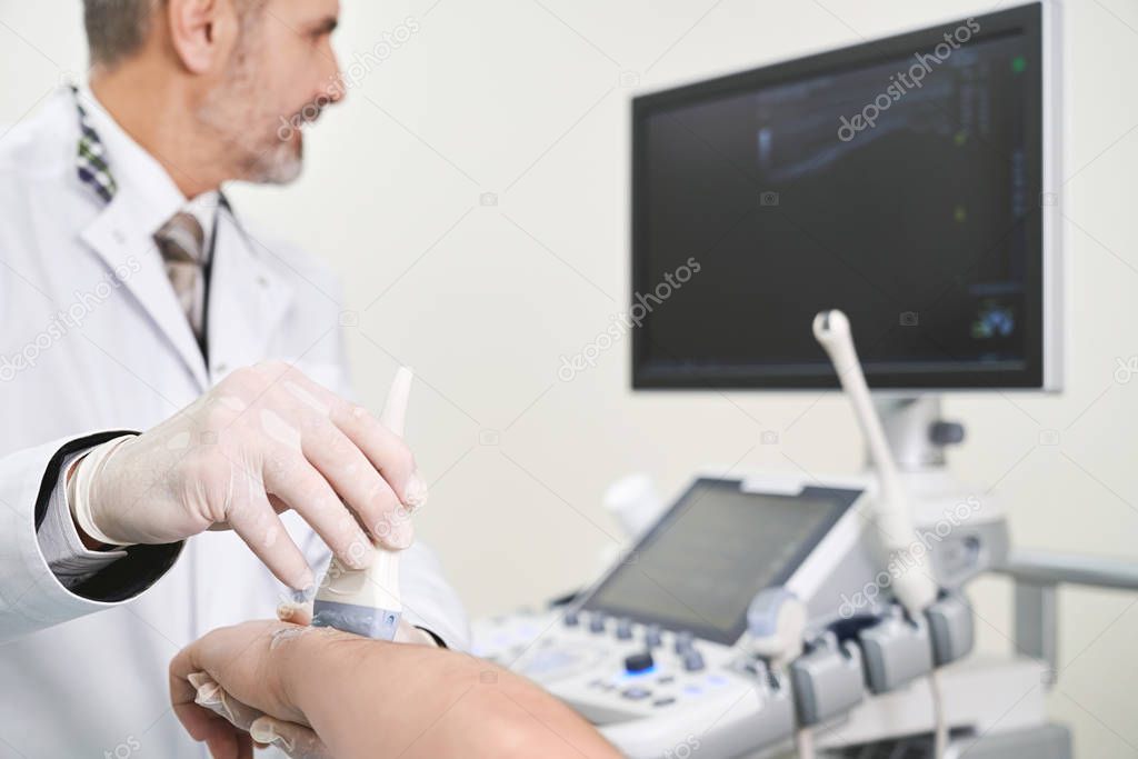 Examination of elbow with ultrasound probe.