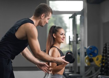 Yardım ve enerjik sportif kız destekleyen uygun eğitmen.