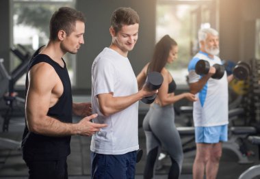 Spor salonunda kişisel eğitmenler ile çalışma dışarı insanlar.
