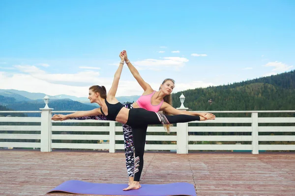 Zwei Frauen üben Halbmond-Pose. — Stockfoto