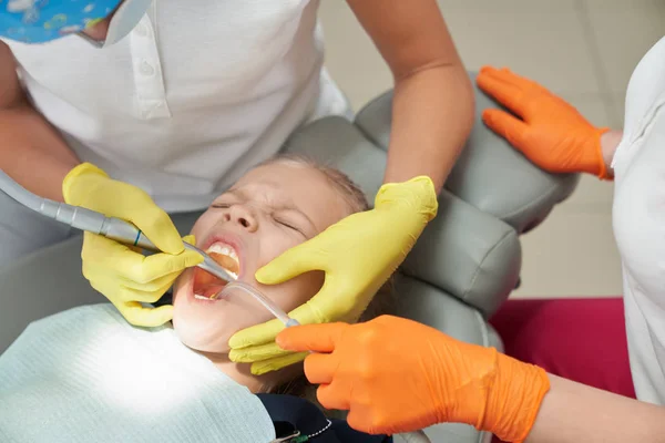 Menina durante o procedimento doloroso no consultório odontológico — Fotografia de Stock