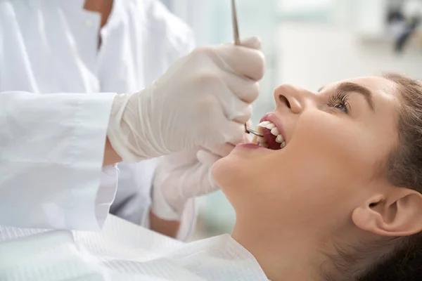 Primer plano de la mujer acostada en la silla dental con la boca abierta — Foto de Stock