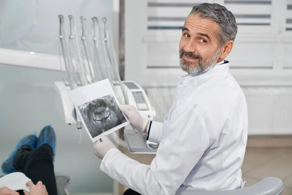 Bonito dentista segurando raio-x dental . — Fotografia de Stock