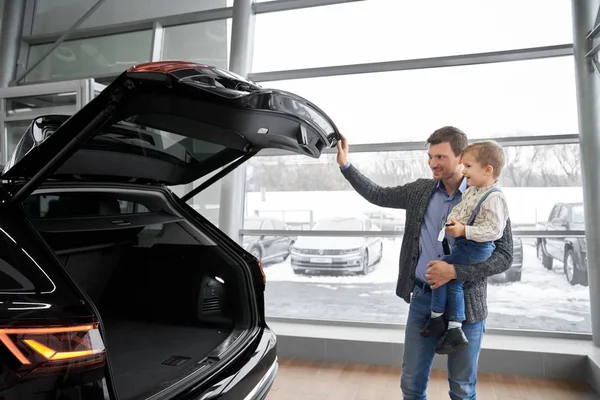 Pai abrir carro tronco, mostrando auto para filho . — Fotografia de Stock