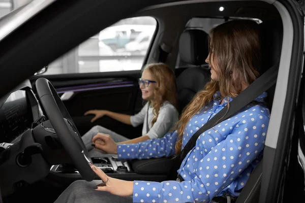Kvinna och dotter testa nya dyra bil. — Stockfoto