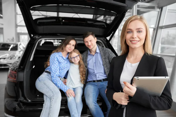 Hermoso gerente de concesionario y familia feliz posando . —  Fotos de Stock