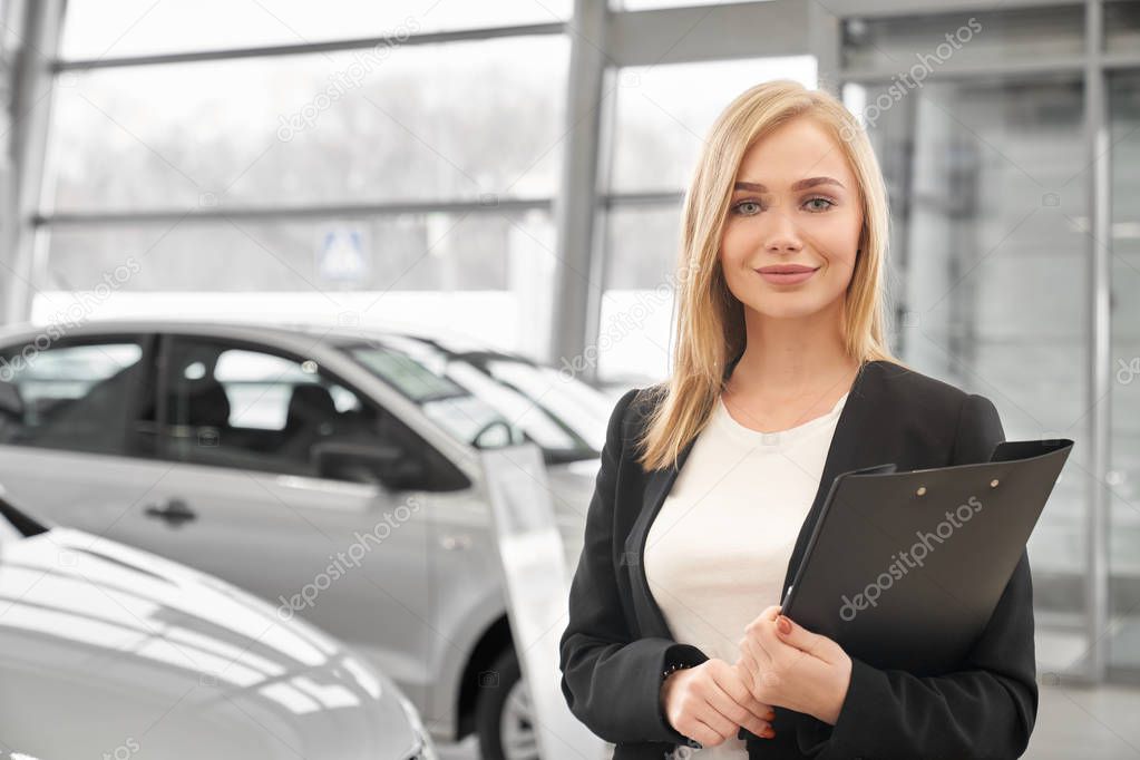 Woman working in car dealership as manager.
