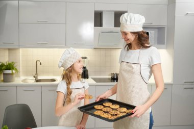 Anne ve kızı levha ve kurabiye pişirme ile poz.