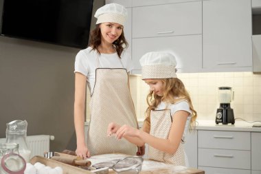 Anne poz, gülümseyen, kızı pişirme bisküvi.