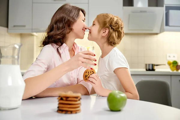 Mãe e filha segurando copo de leite, biscoitos amerianos . — Fotografia de Stock