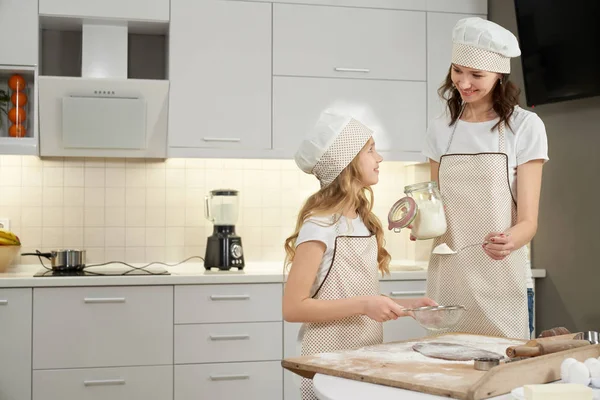 Mother and daughter making dough in kitchen. — Stock Photo, Image