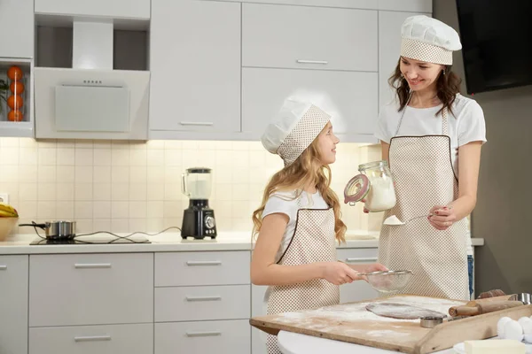 Mor och dotter tjänar pengar i köket. — Stockfoto