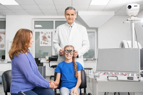 Médico revisando la vista de la chica con gafas de prueba . — Foto de Stock